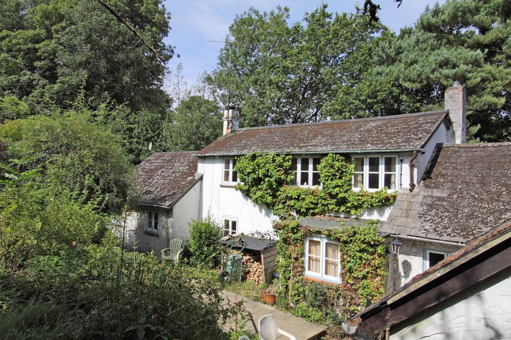 Lot: 113 - DETACHED COTTAGE FOR IMPROVEMENT ON 0.3 ACRE PLOT - Picture showing front elevation of rendered white cottage and slate tile roof